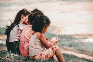 Group of children sitting on bench.