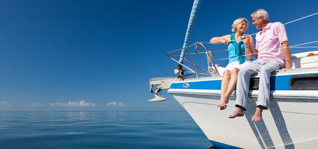 Older couple embracing on a boat overlooking a body of water